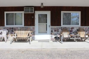 Motel Suite 10 exterior, charcoal grill and wooden chairs